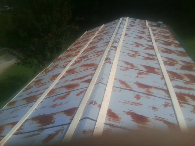 Rusted metal roof panels with new wood purlins before replacement — Storm Damage Roof Repair in Giddings by Roofing Brothers