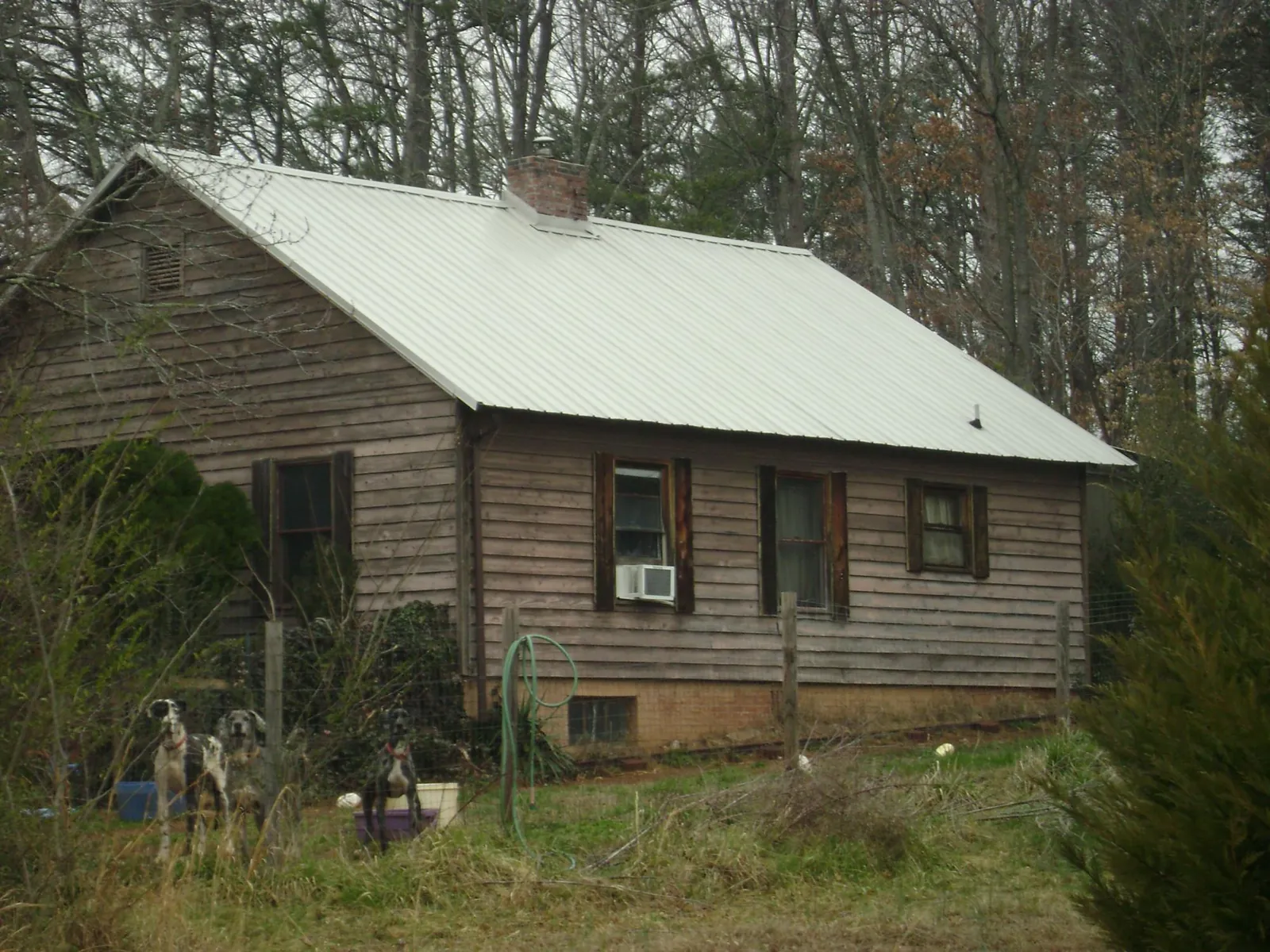 White metal roof on an old wood sided farmhouse, from a Metal Roof Installation job in Giddings